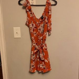 Rue 21 orange romper with flowers all over.Size Small.Never worn, new with tag.